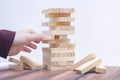 A tower of wooden blocks and a manÃ¢â¬â¢s hand take one block. board game Royalty Free Stock Photo